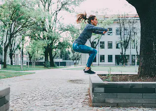 Woman does a jump squat, one of the best plyometric exercises