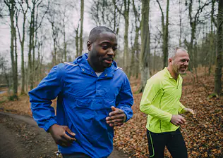 Two men running outside on a trail