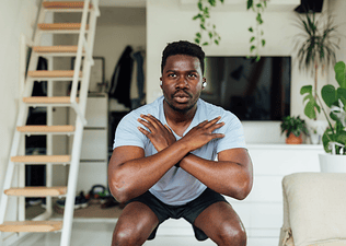 Man does a squat, practicing strength training exercises for triathletes