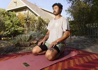 Peloton member working out on a yoga mat outside