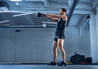 Man doing a kettlebell swing inside