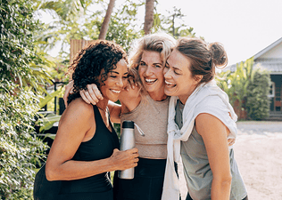 Three women embracing each other outside
