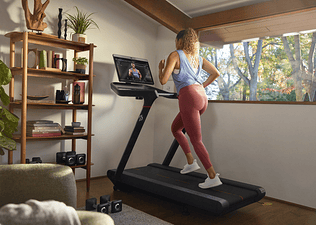 Woman runs on a Peloton Tread at home
