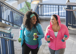 women walking with hand weights