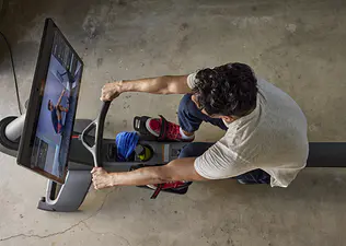 Man looks at his strokes per minute on a rowing machine