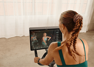 A woman rides on a Peloton Bike