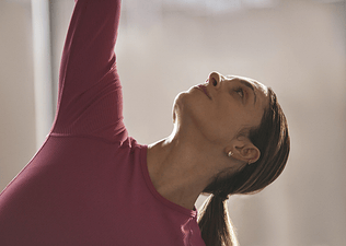 Woman stretches while looking up 
