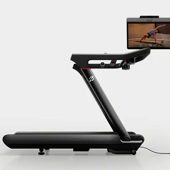 the Peloton Tread Vision treadmill with the screen swiveled to show a yoga class