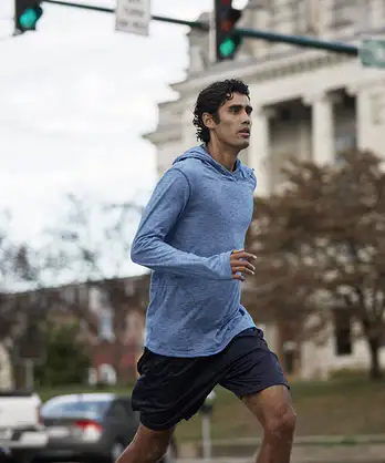 A man practicing discipline by going on a jog through the city.