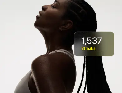 A lady in a white top facing upwards in dark lighting with the words 1,537 streaks overlaid on the image