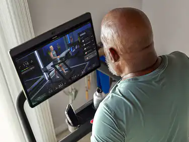 man on Peloton Tread at home