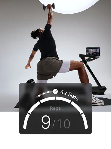 Ein Mann kniet auf einer Matte und streckt einen Arm über den Kopf, während er eine Hantel hält, neben einem Peloton Tread+. Das Overlay zeigt „Wiederholungen 5/6“.