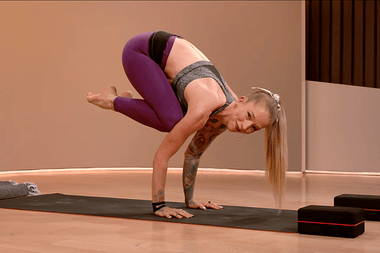 Peloton Instructor doing a yoga crow pose