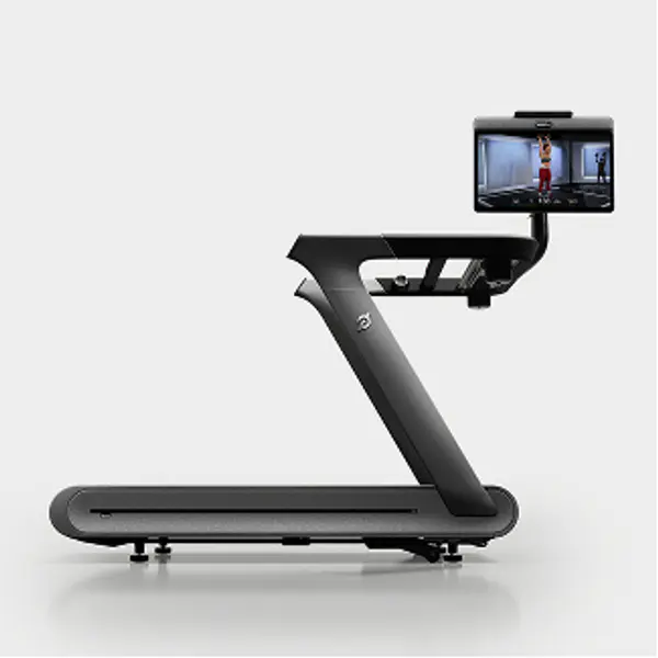 Side profile of a Peloton Tread Plus showing the slatted belt, sleek frame, and attached HD touchscreen.