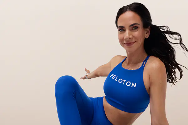 Instructor in a blue Peloton outfit posing during a yoga session.