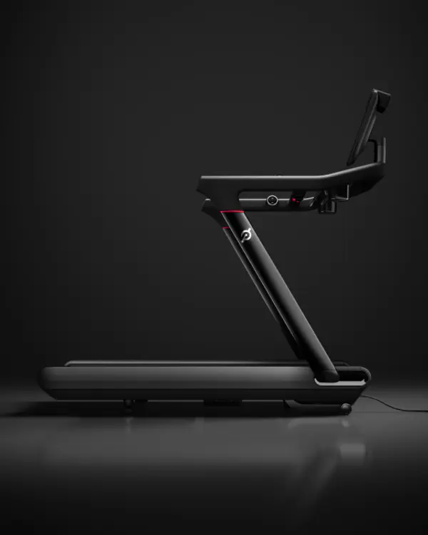 Side profile of a Peloton Tread treadmill on a dark background.