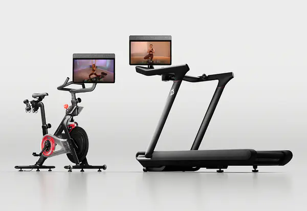 Peloton Bike and Peloton Tread side by side, each with a large touchscreen display showing workout content.