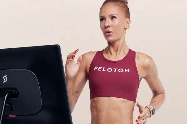 Instructor running on a Peloton Treadmill while looking ahead with focus.
