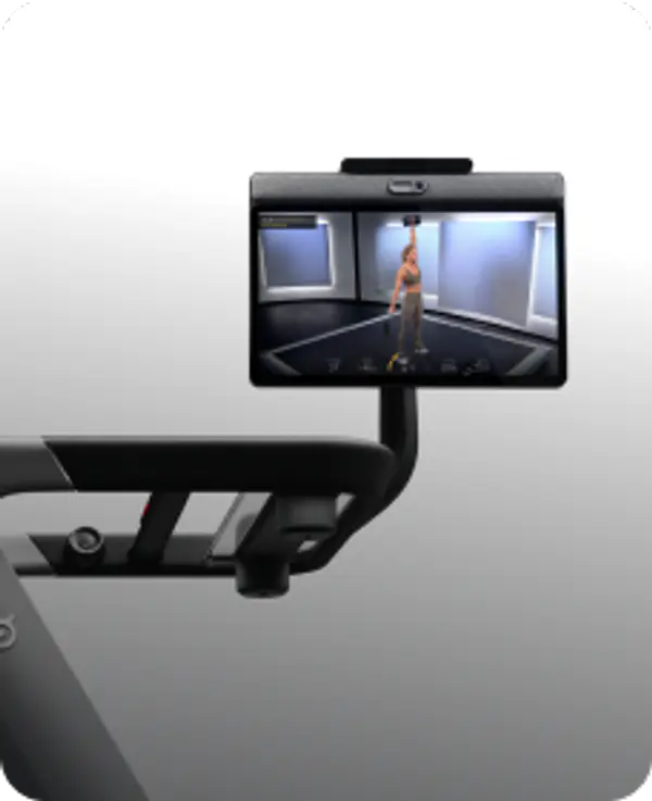 Close-up of a Peloton Tread console and handlebars with a screen showing a fitness instructor during a workout.