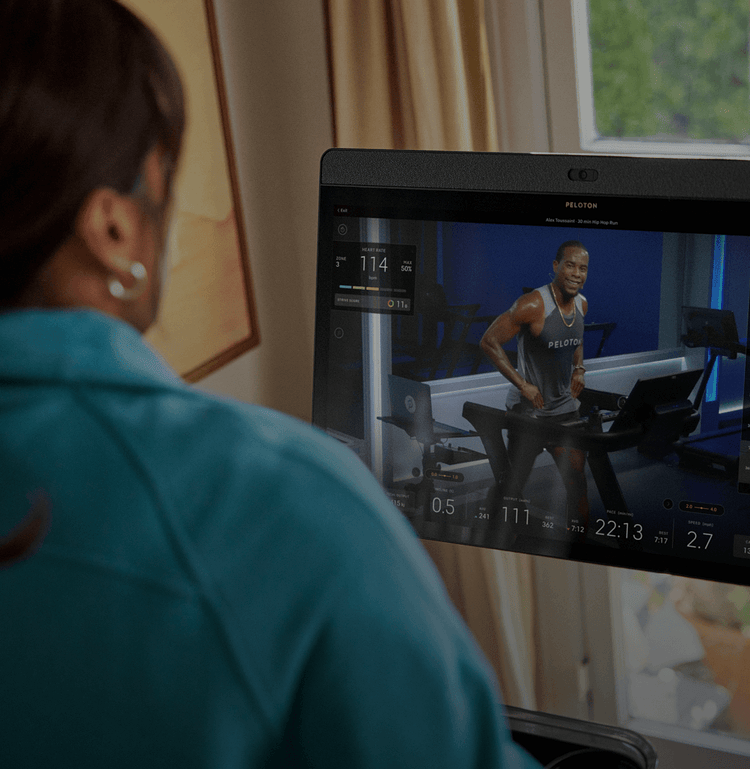 Woman taking a Peloton Tread class at home