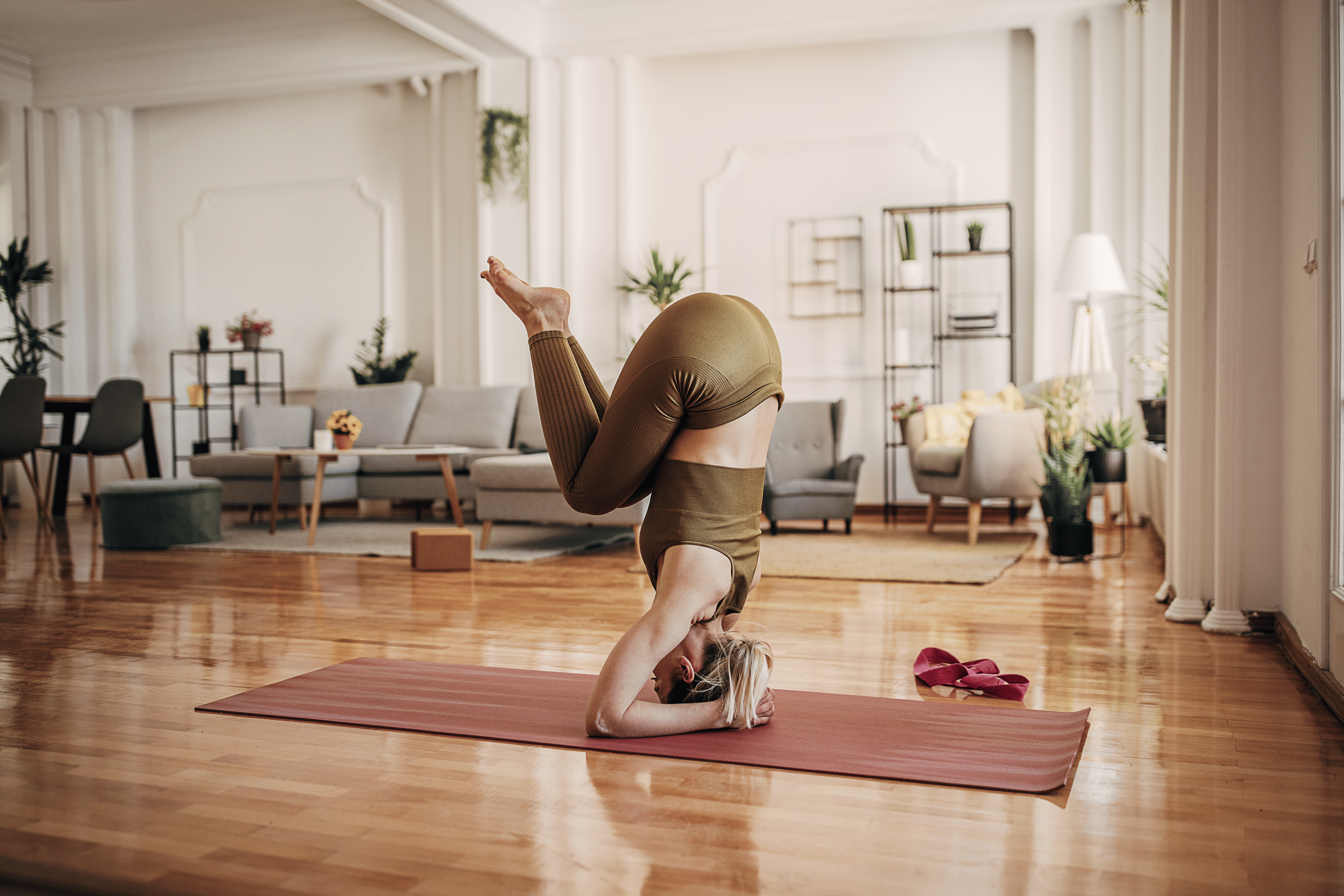 Woman doing a yoga headstand during a home yoga practice