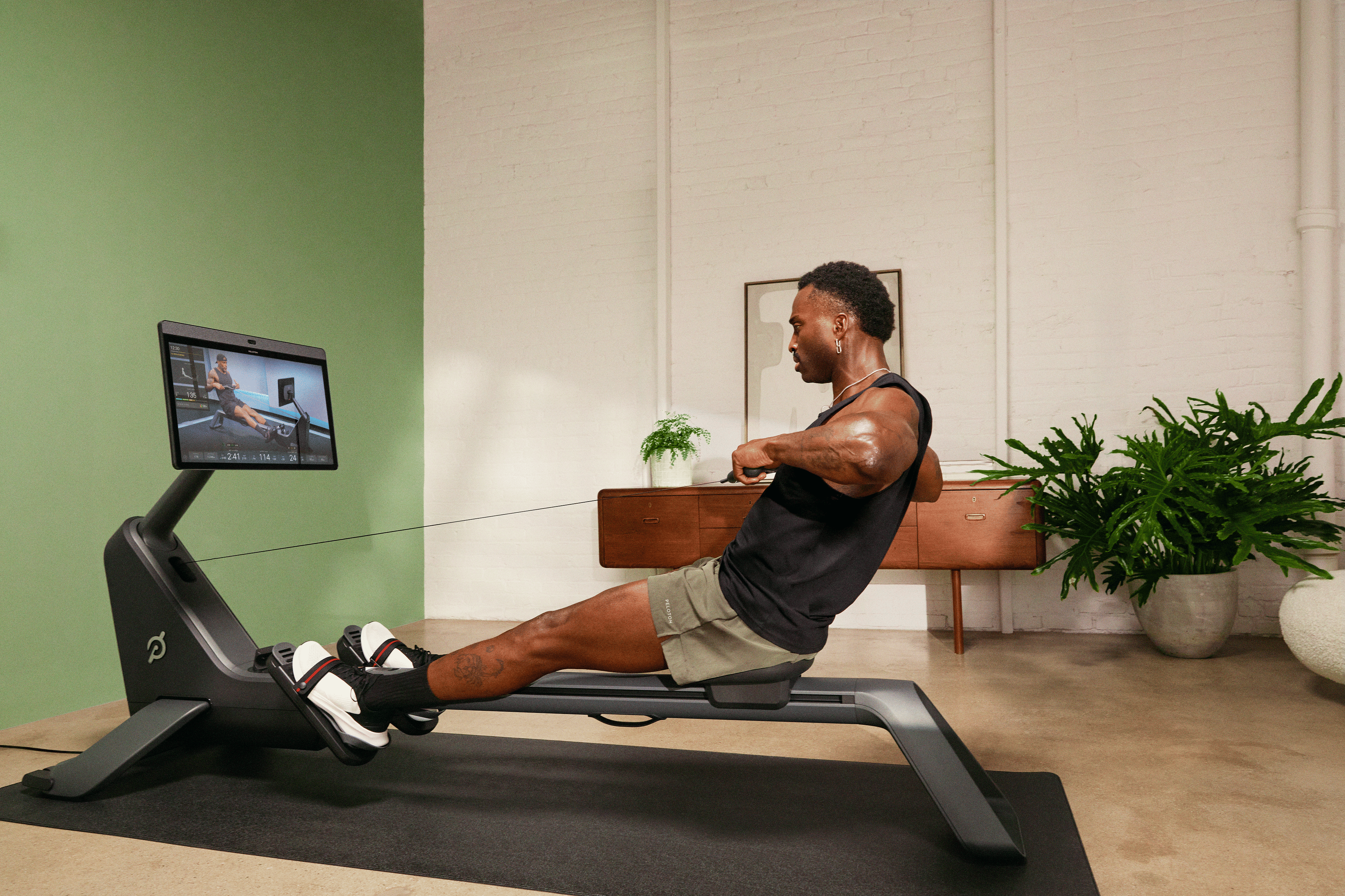 Man exercising on Peloton Row activating all the muscles worked by rowing.