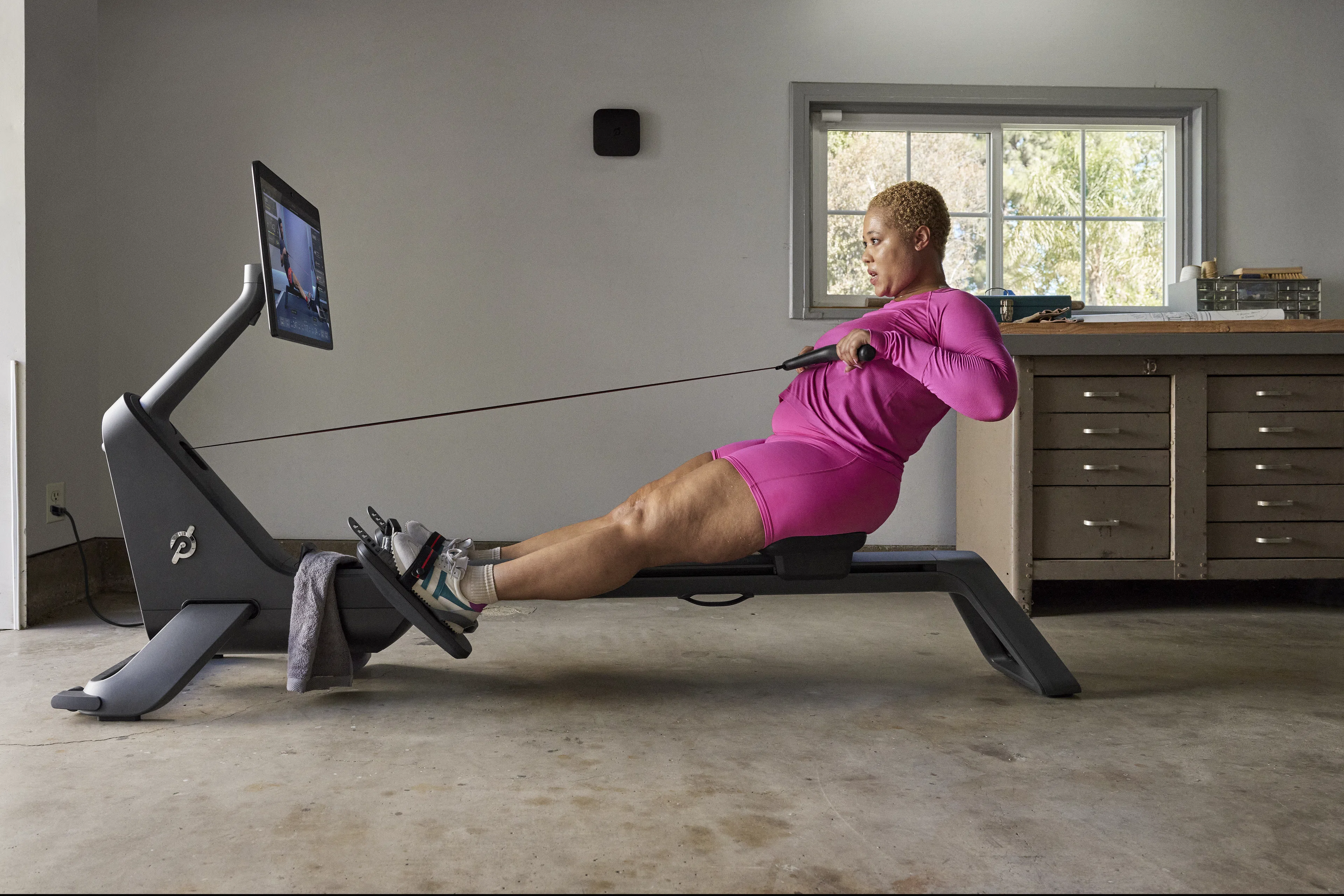 Woman does a Peloton Row workout at home 