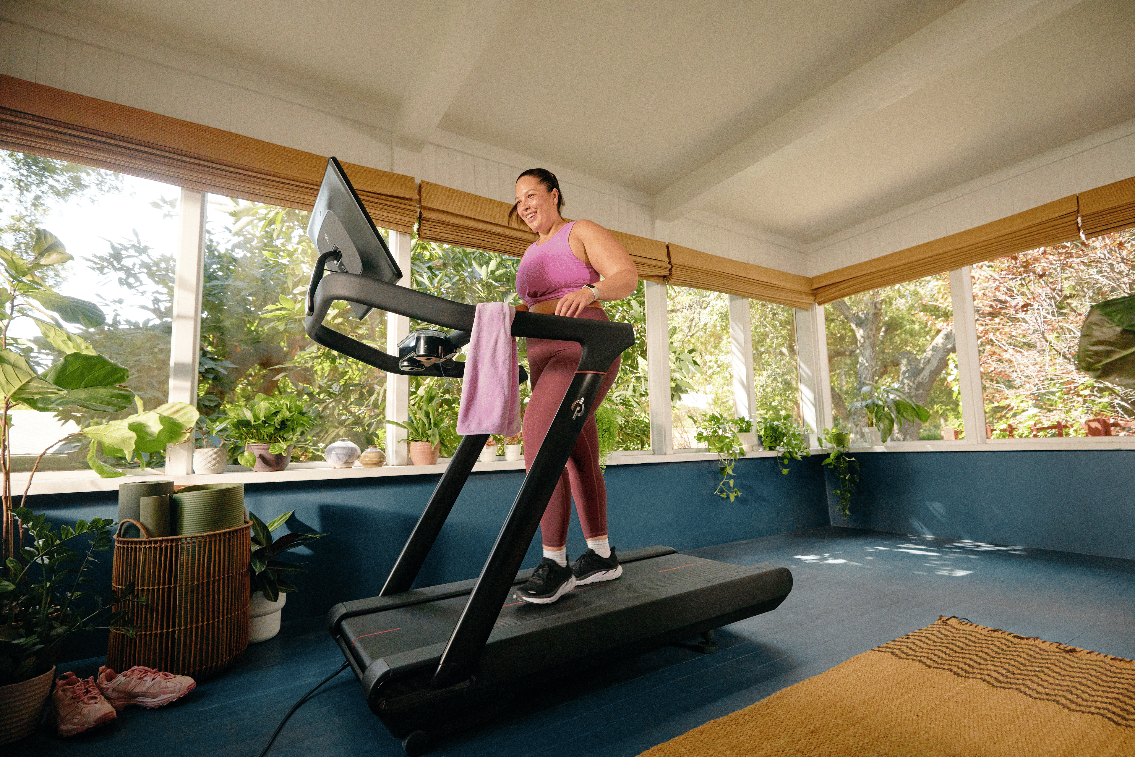Woman exercising at home on the Peloton Tread+ while reaping the mental health benefits of running