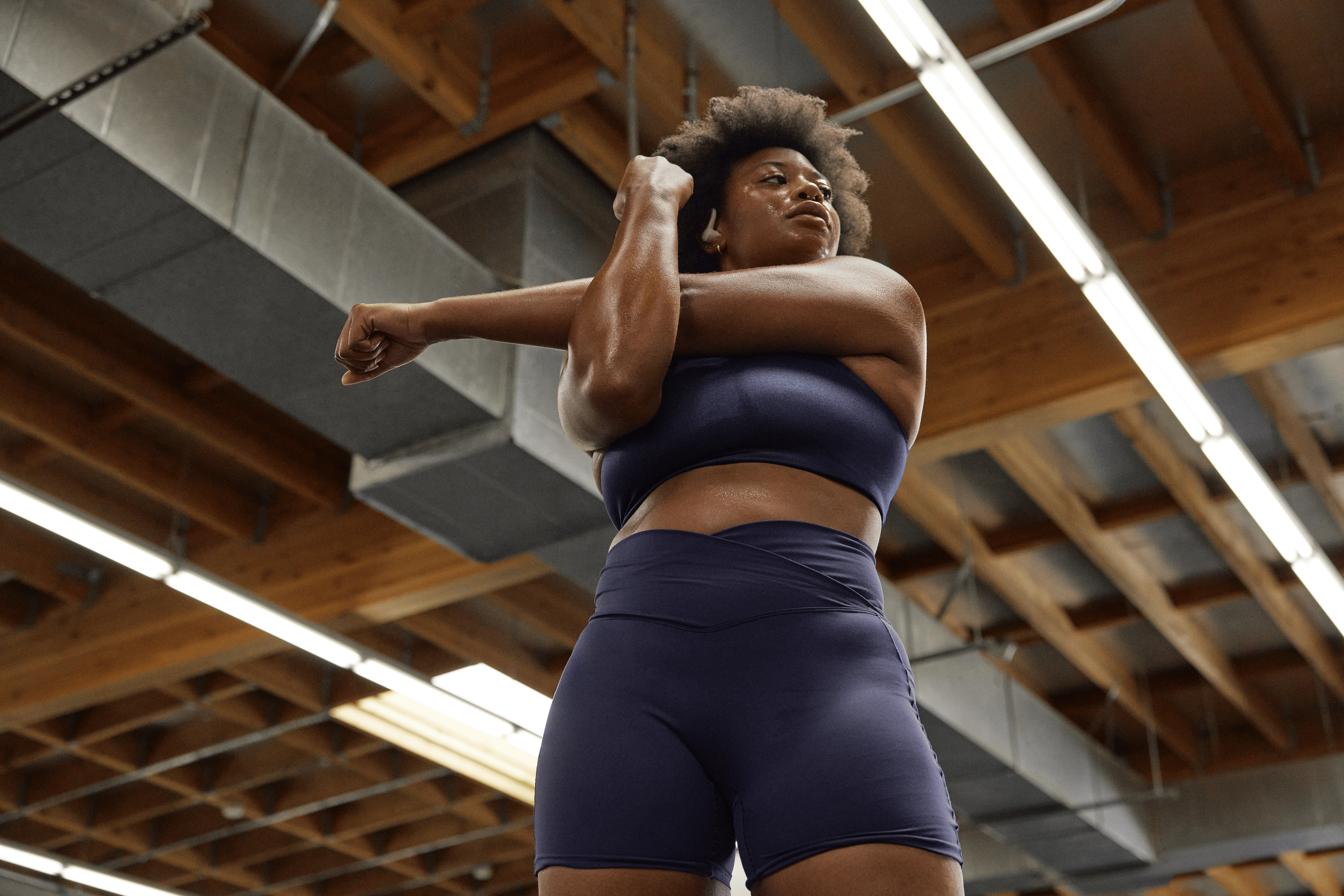 Woman stretches at the gym; stretching can be part of a deload week