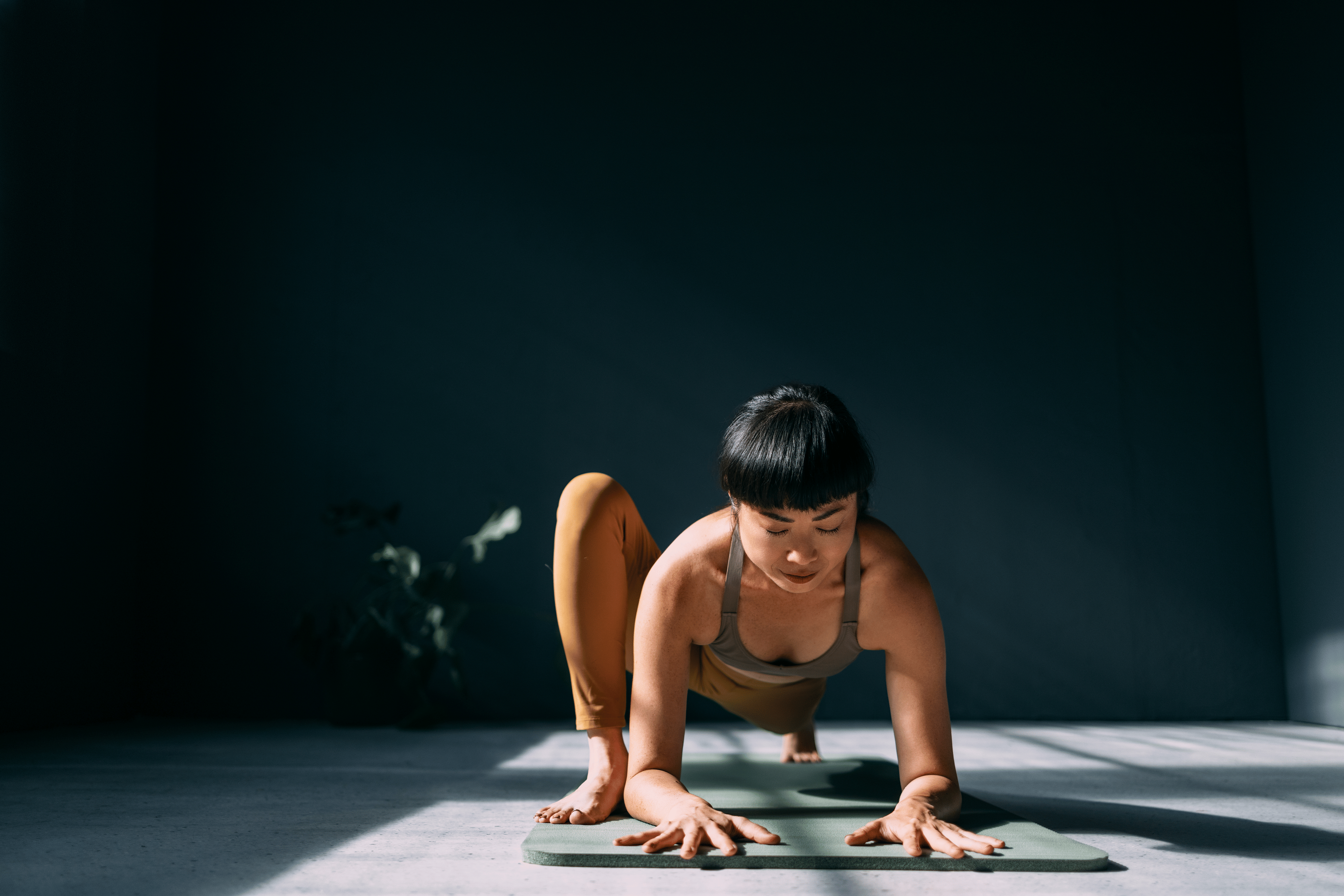 Woman doing Lizard Pose in yoga in a studio space