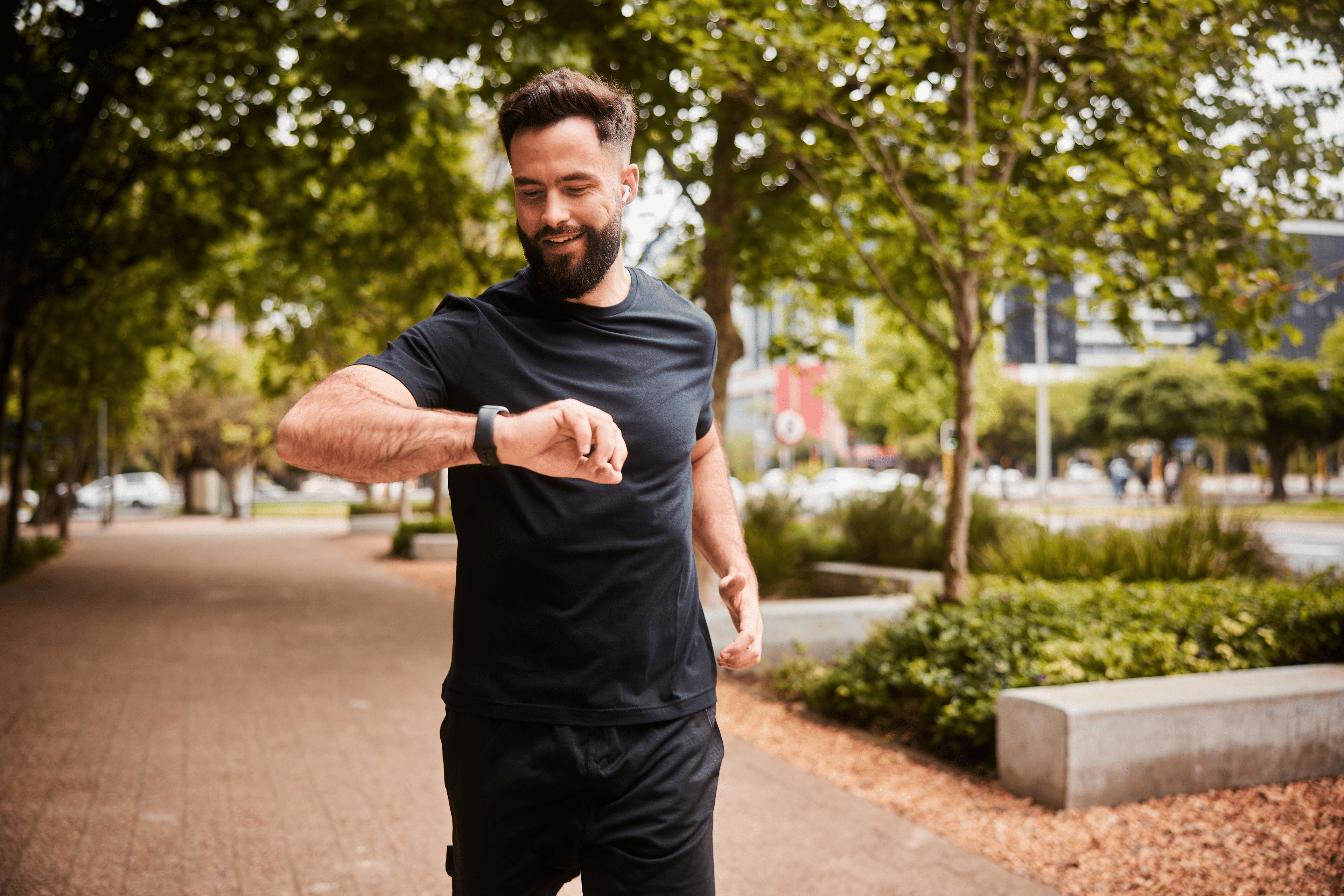 Man checking watch while running outside