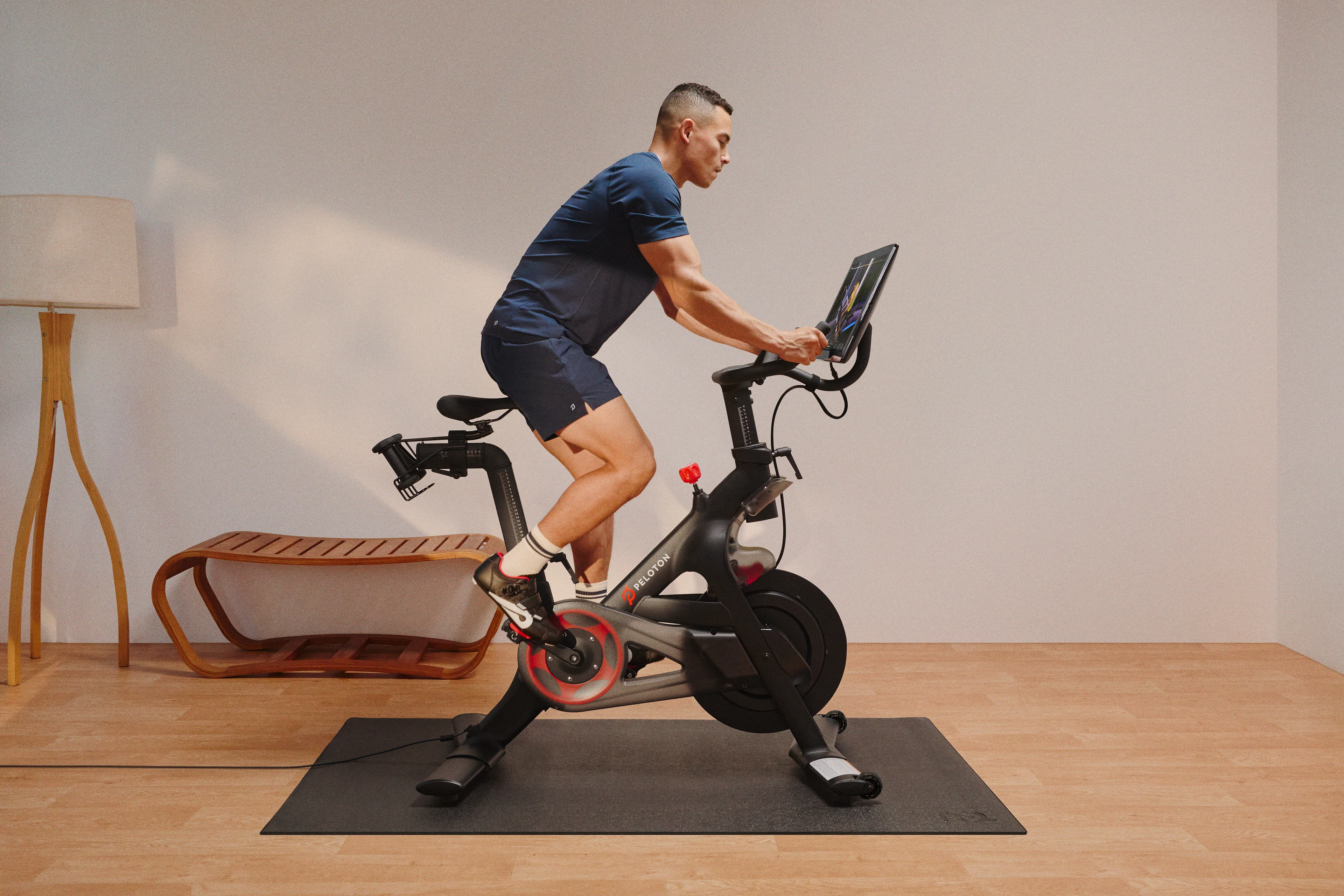 Man doing a cardio workout on a Peloton Bike.