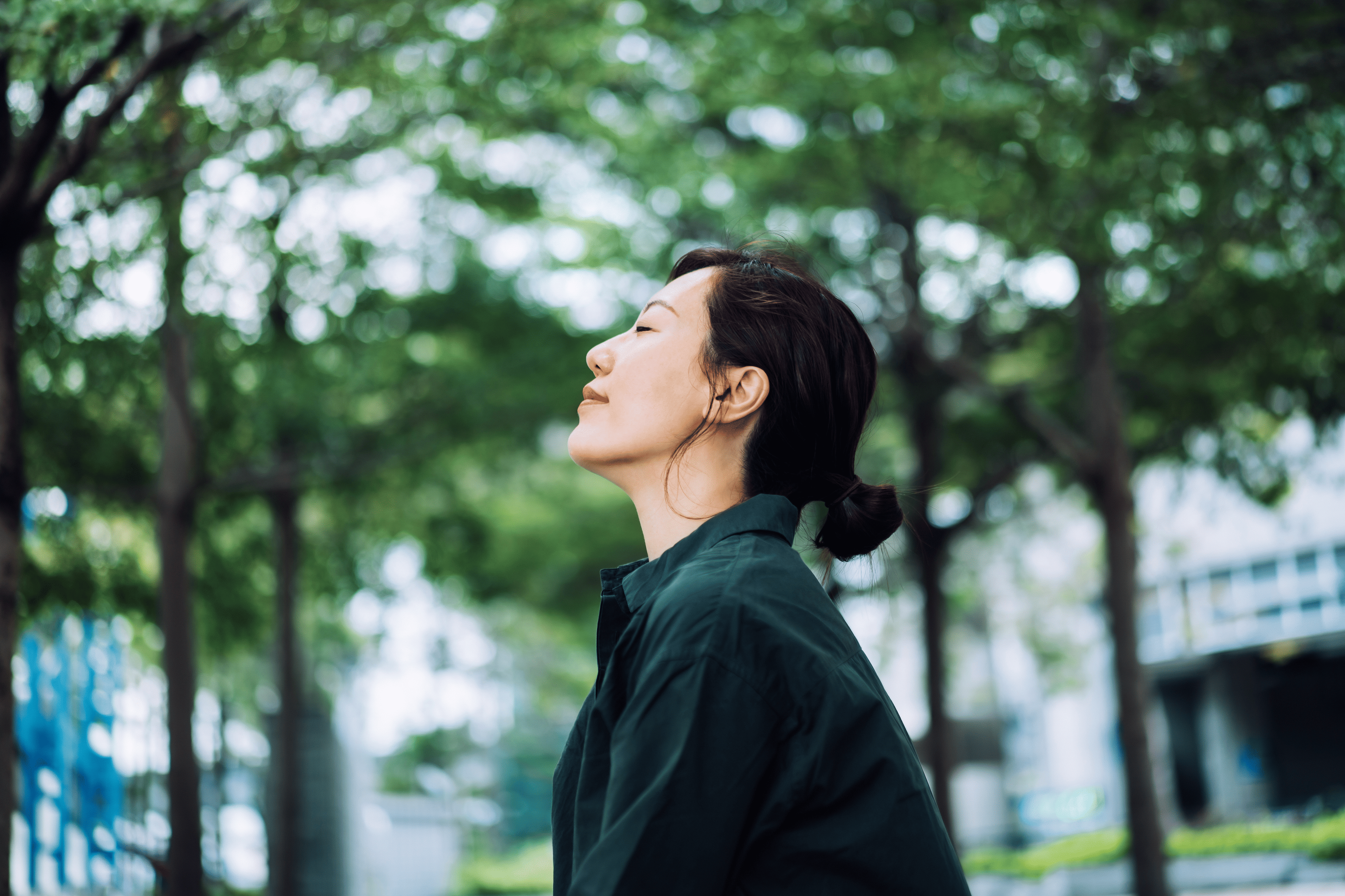 side profile of woman with eyes closed in the woods