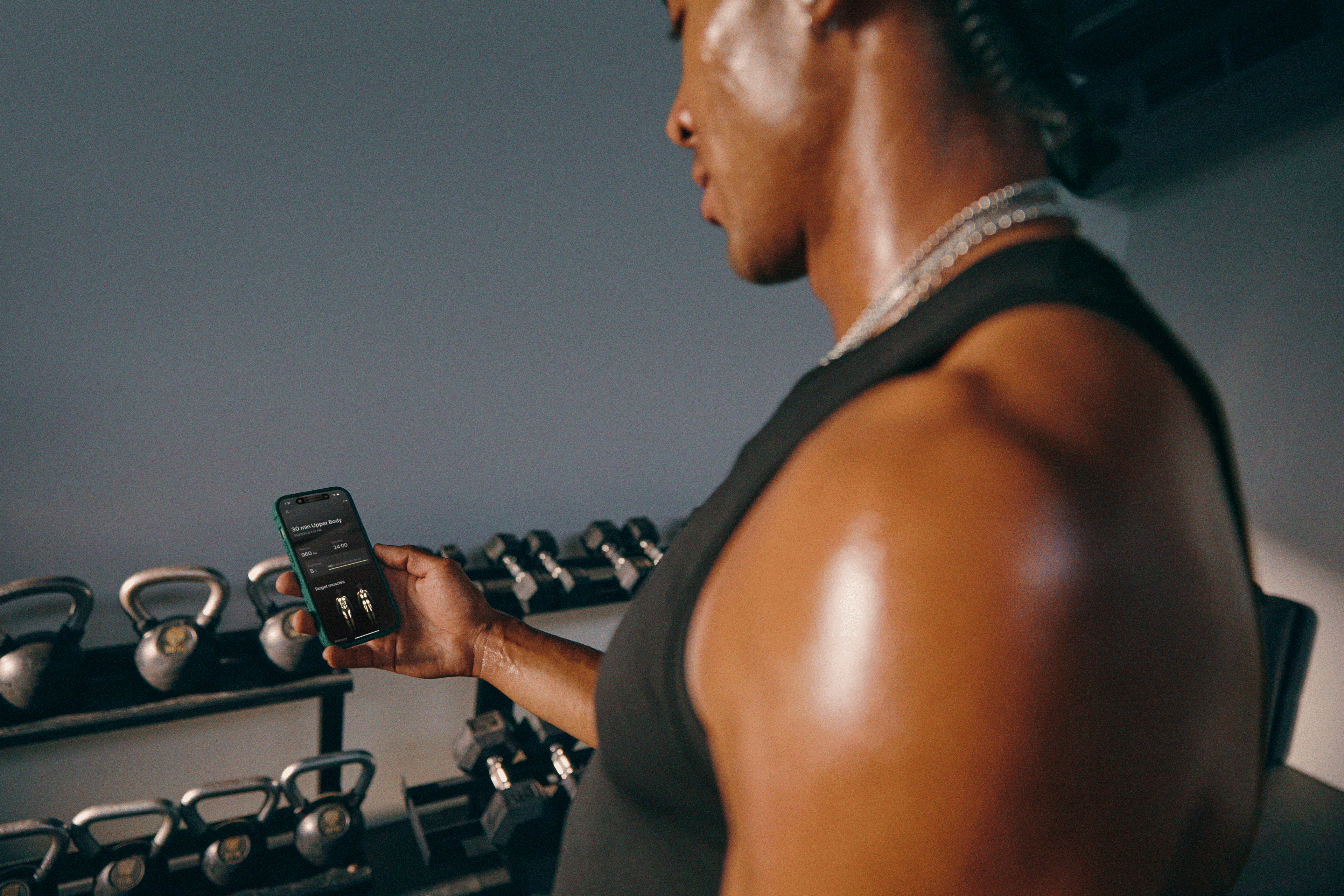 Man using the Peloton Strength+ app in the gym wondering which weights during a strength training workout.