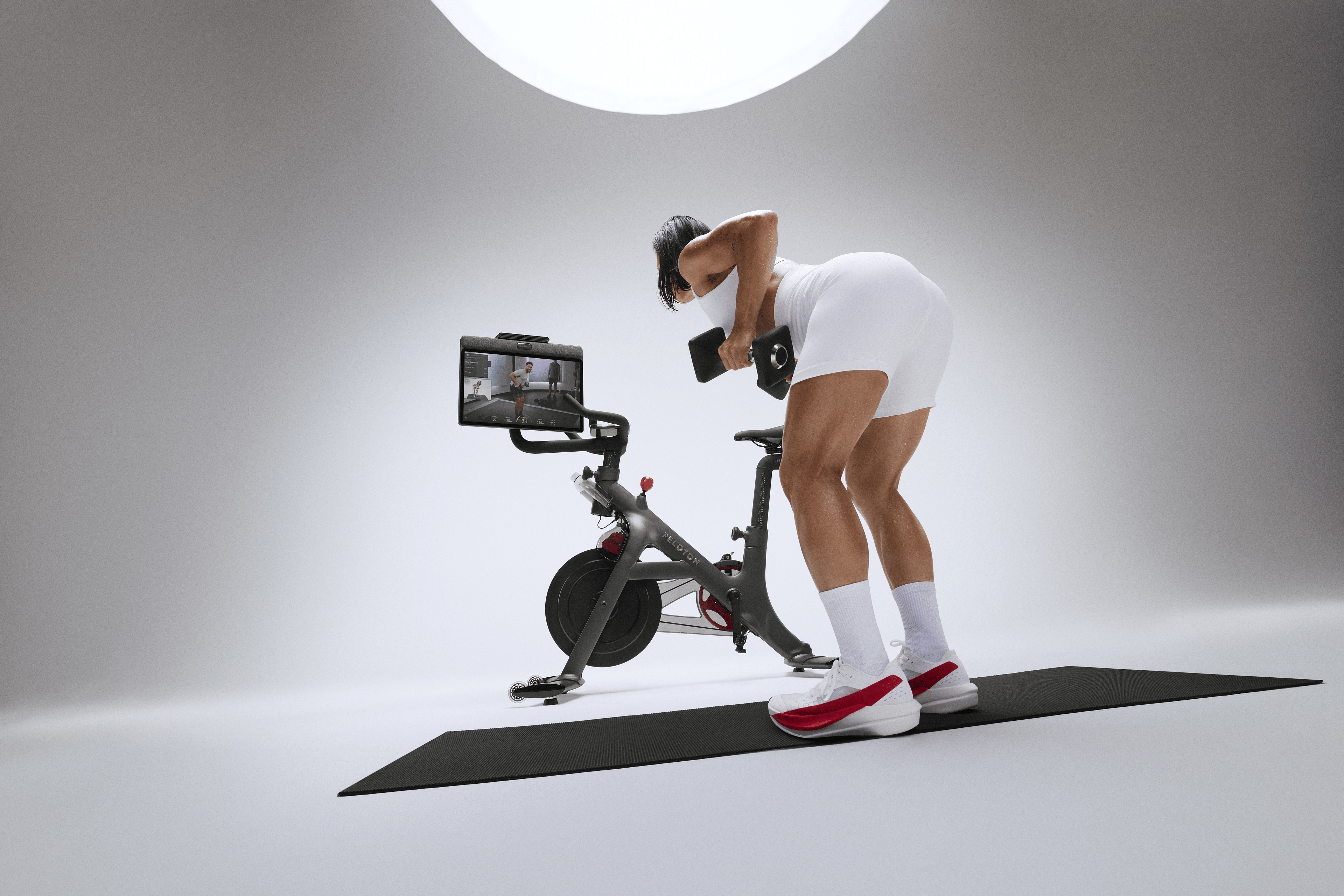 Woman doing a strength workout on the Peloton Cross Training Bike+ Powered by Peloton IQ. 