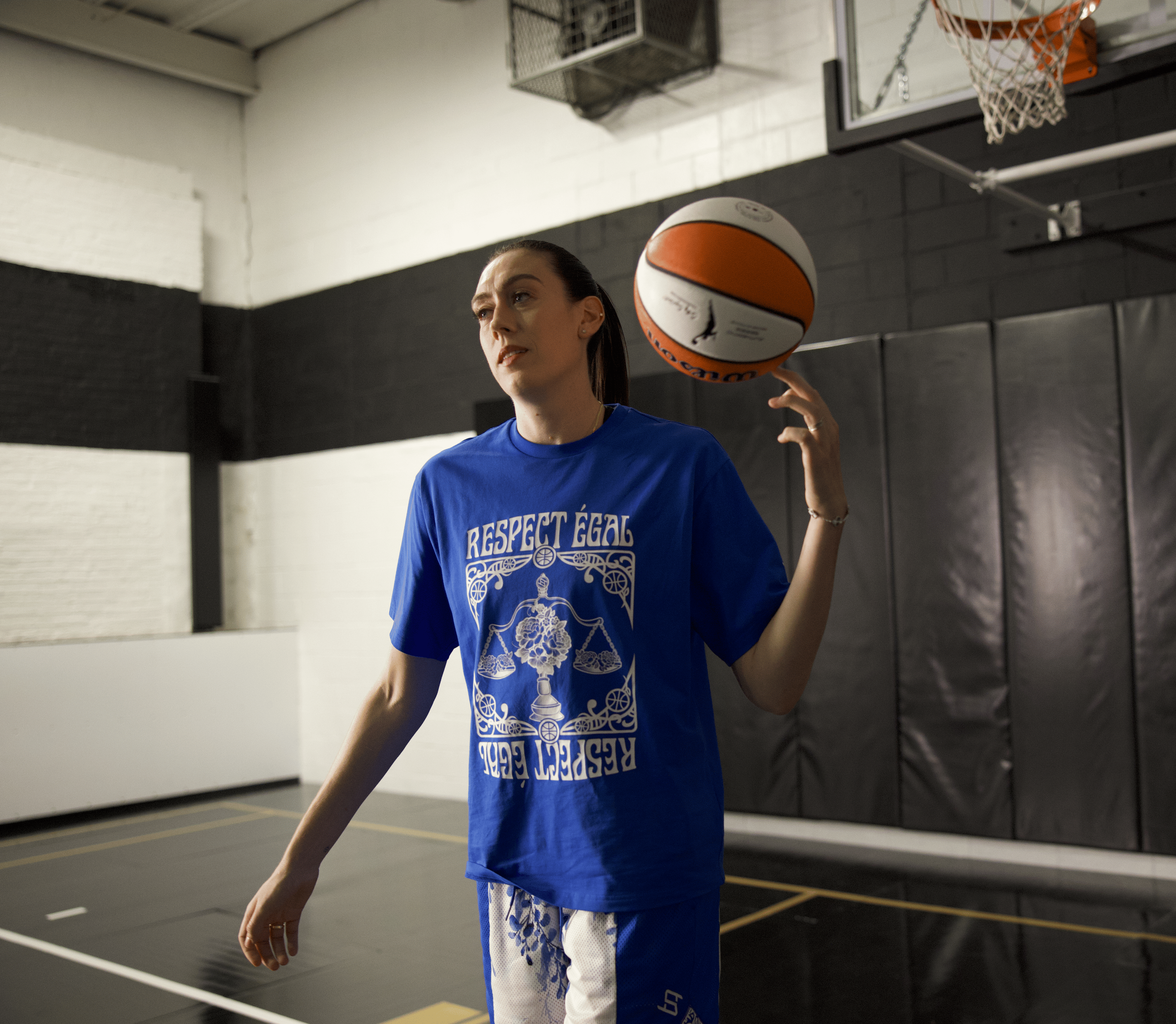 WNBA All-Star Breanna Stewart spinning a basketball on her finger on an indoor basketball court