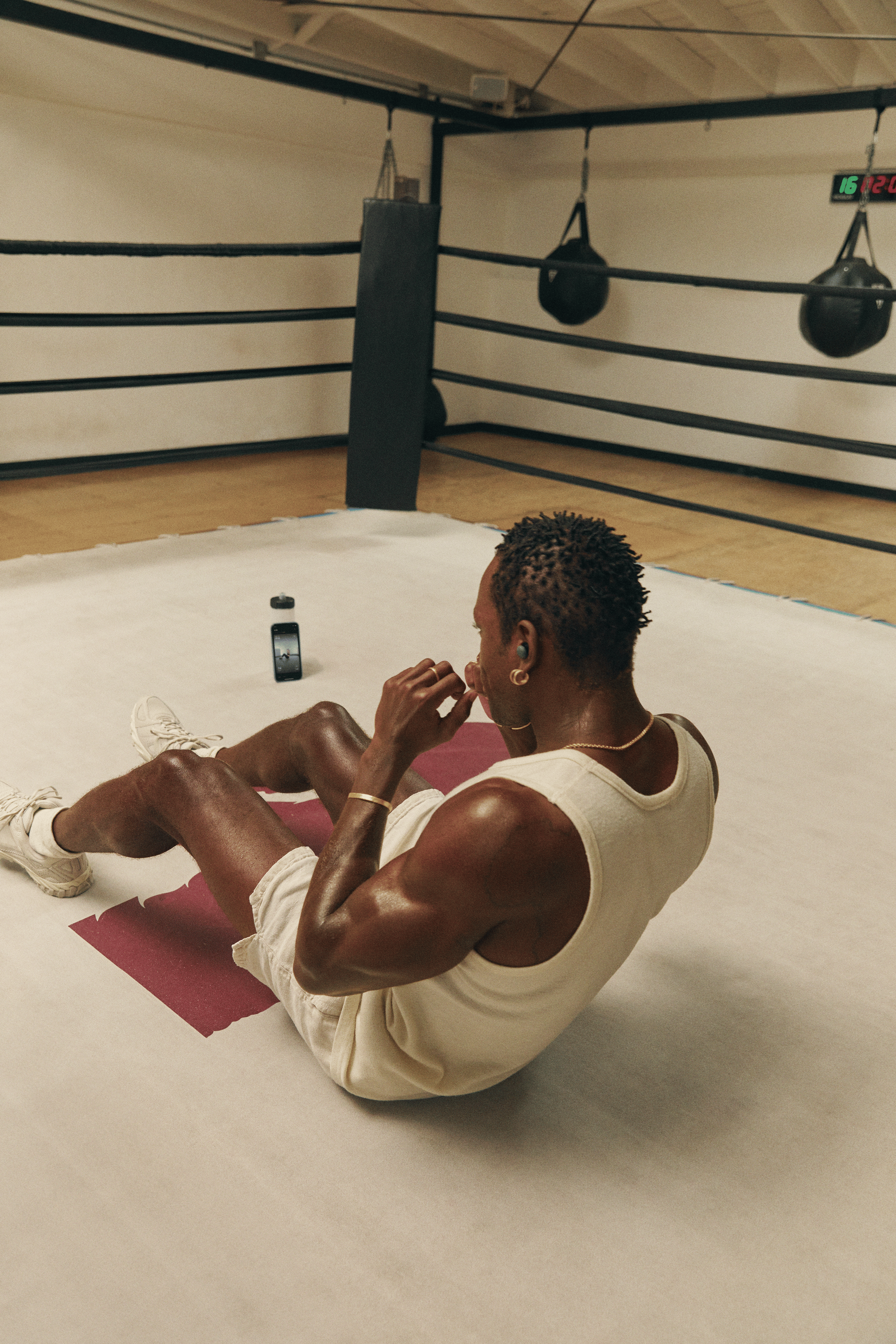Man doing sit ups in a boxing ring as a way to strength train without weights