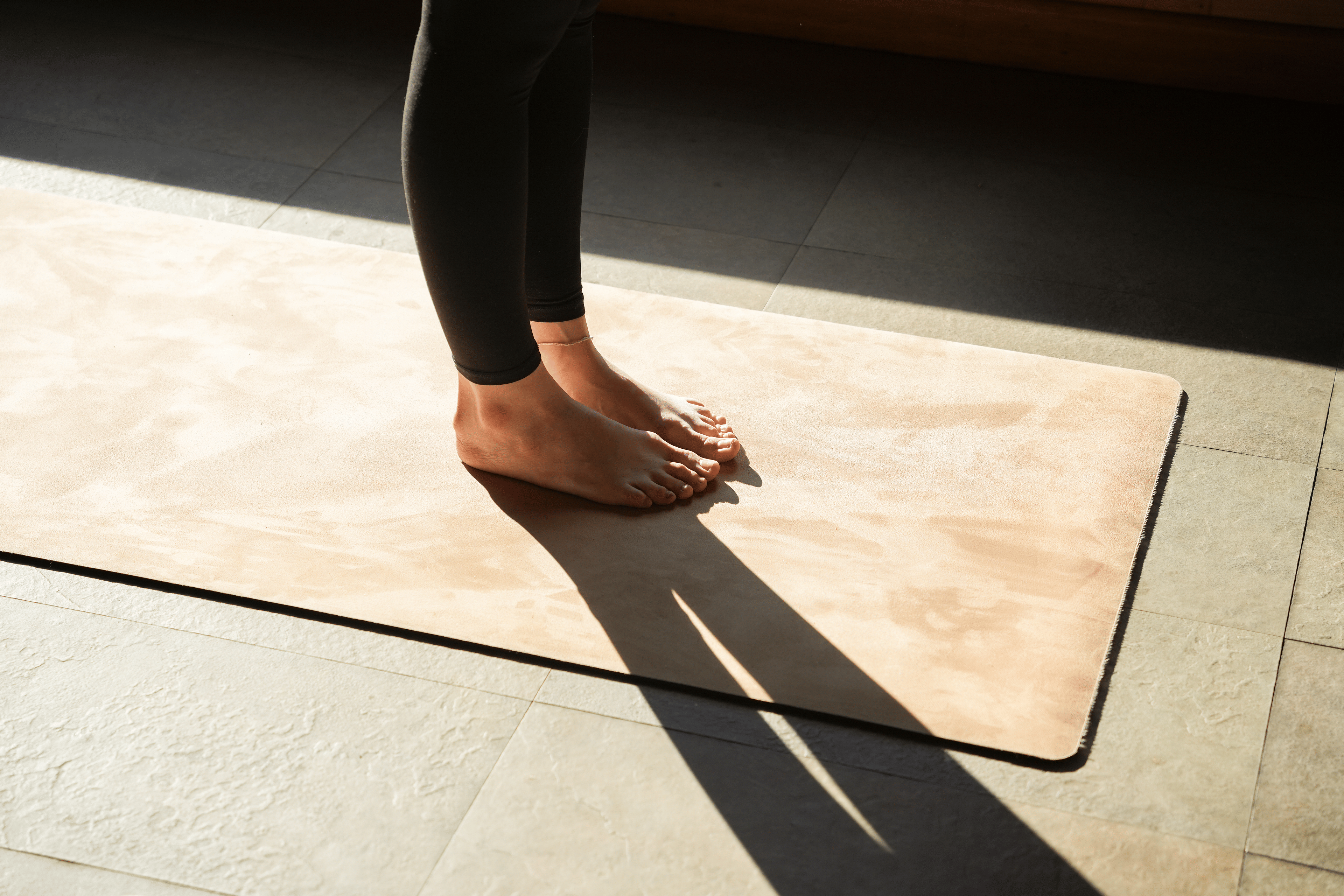 Close up of a woman's feet on a yoga mat while doing ankle mobility exercises