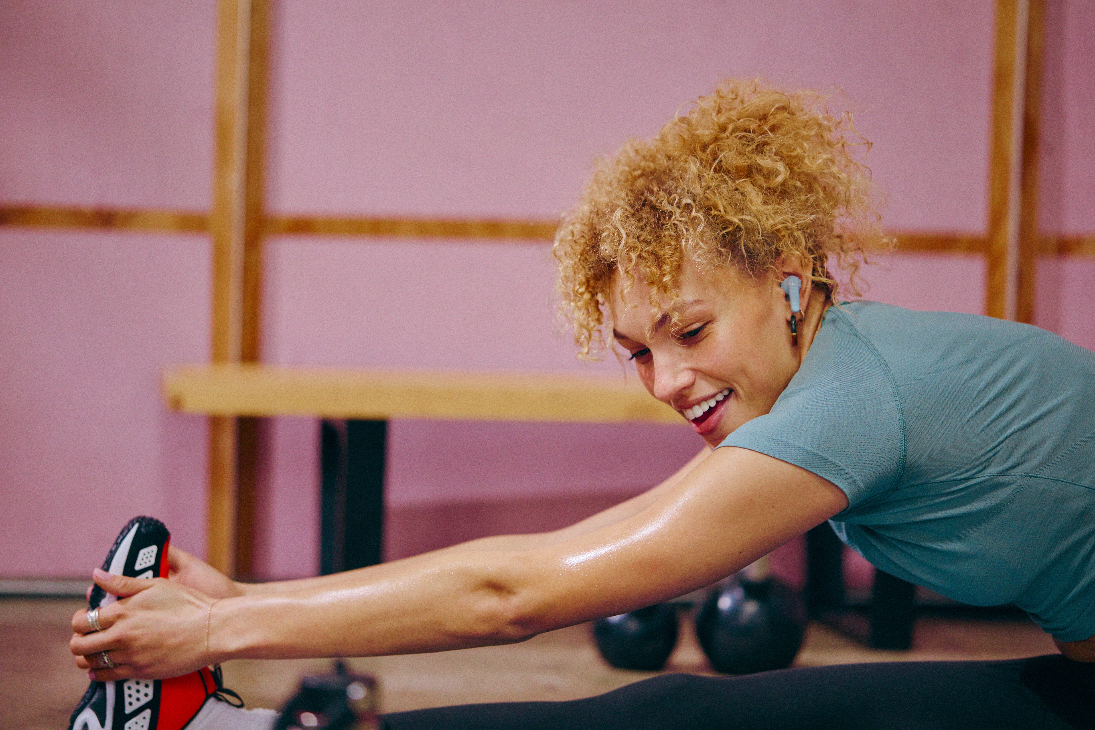 Peloton member doing cooldown exercises and stretching after a workout.