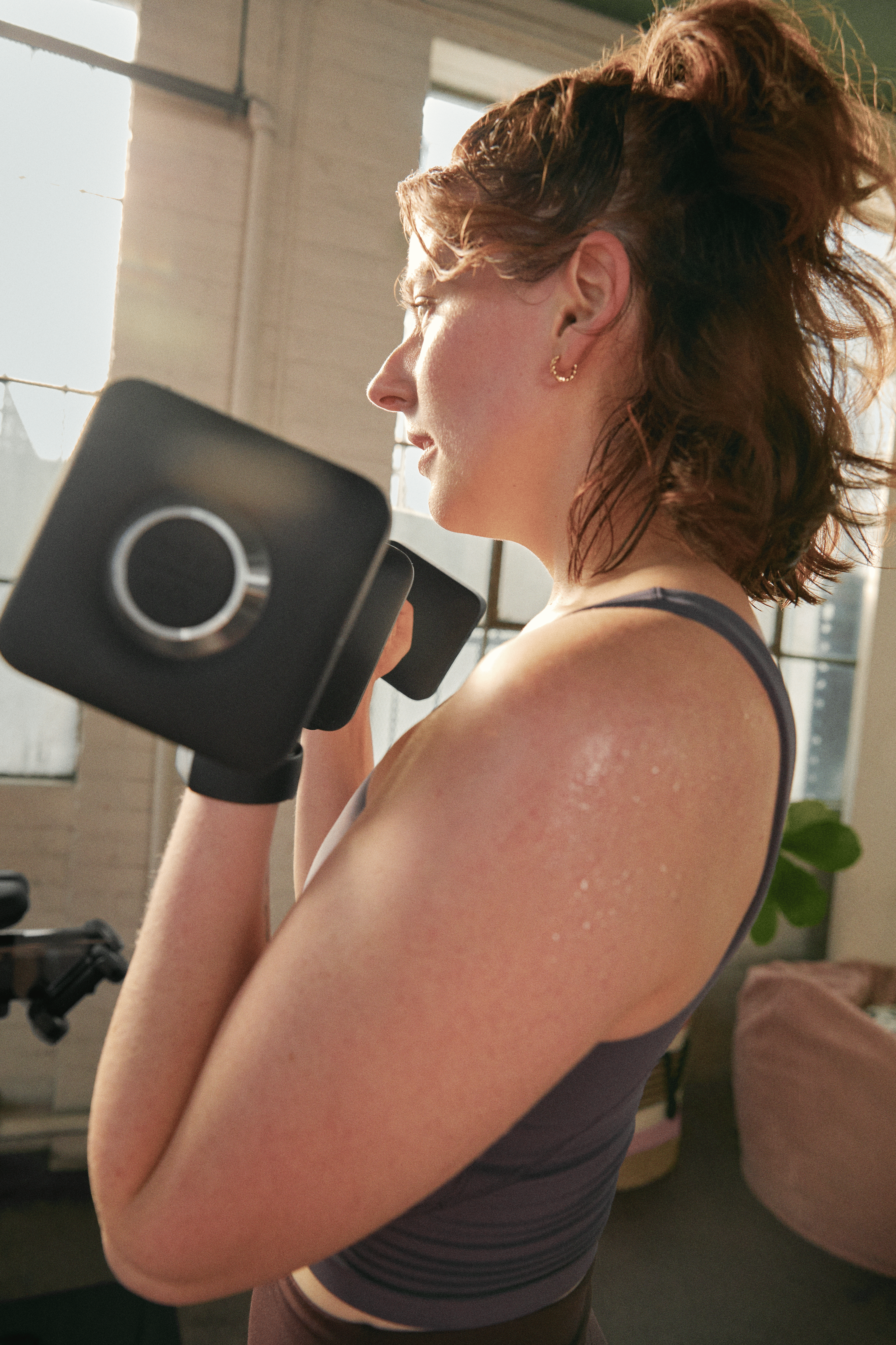 Woman holding dumbbells while doing a superset during a Peloton strength workout