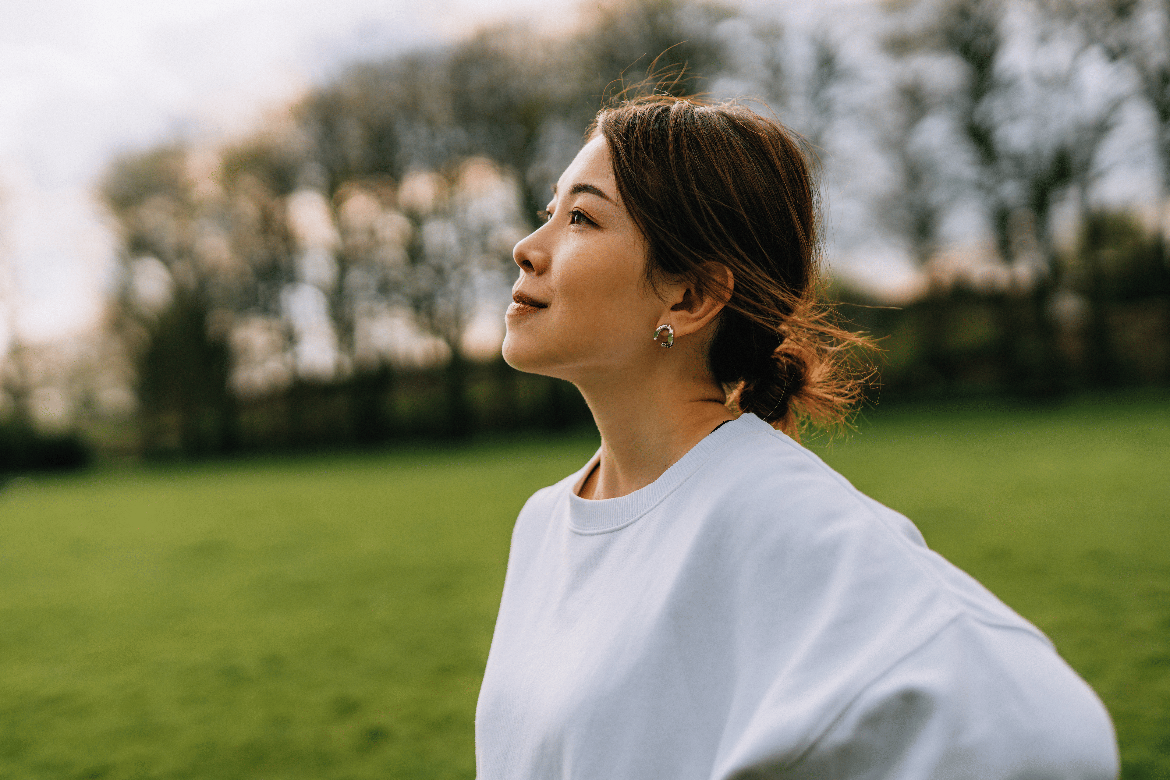 A woman with inner strength. She is standing outside and looking ahead confidently. 