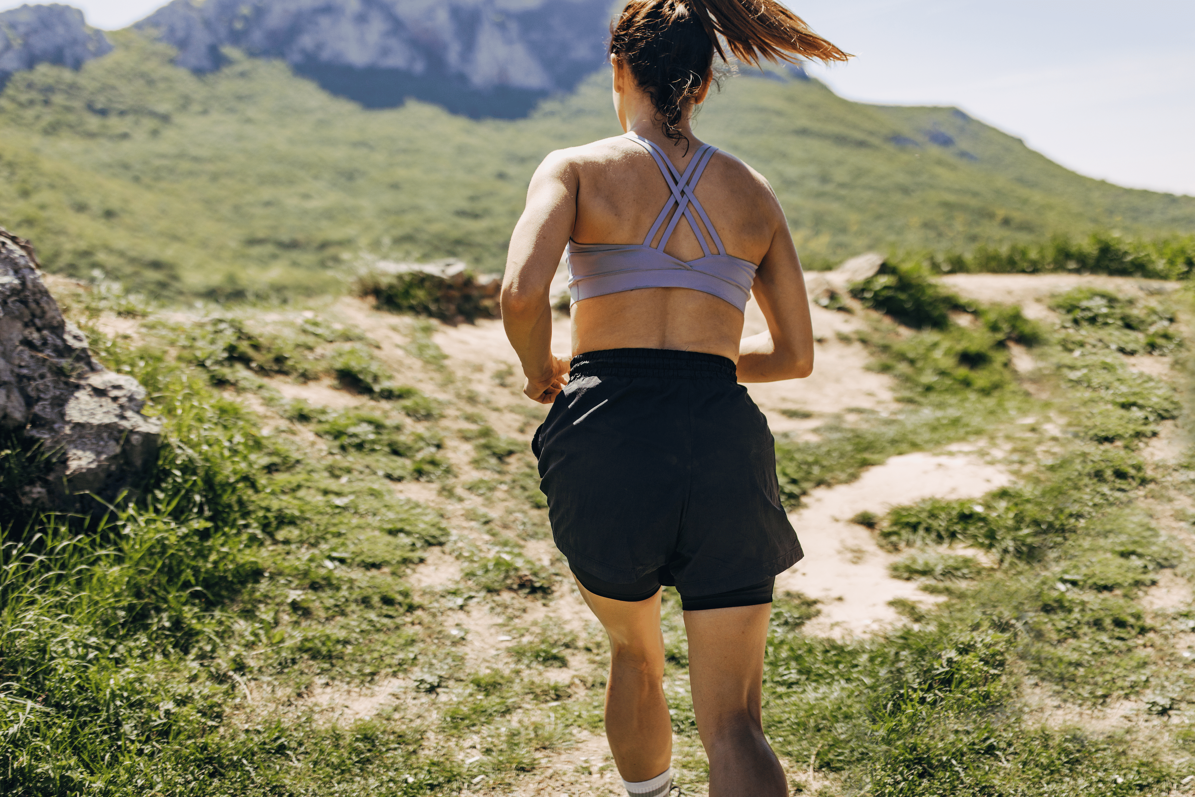 Woman running up a mountain wondering whether or not running is a full body workout.