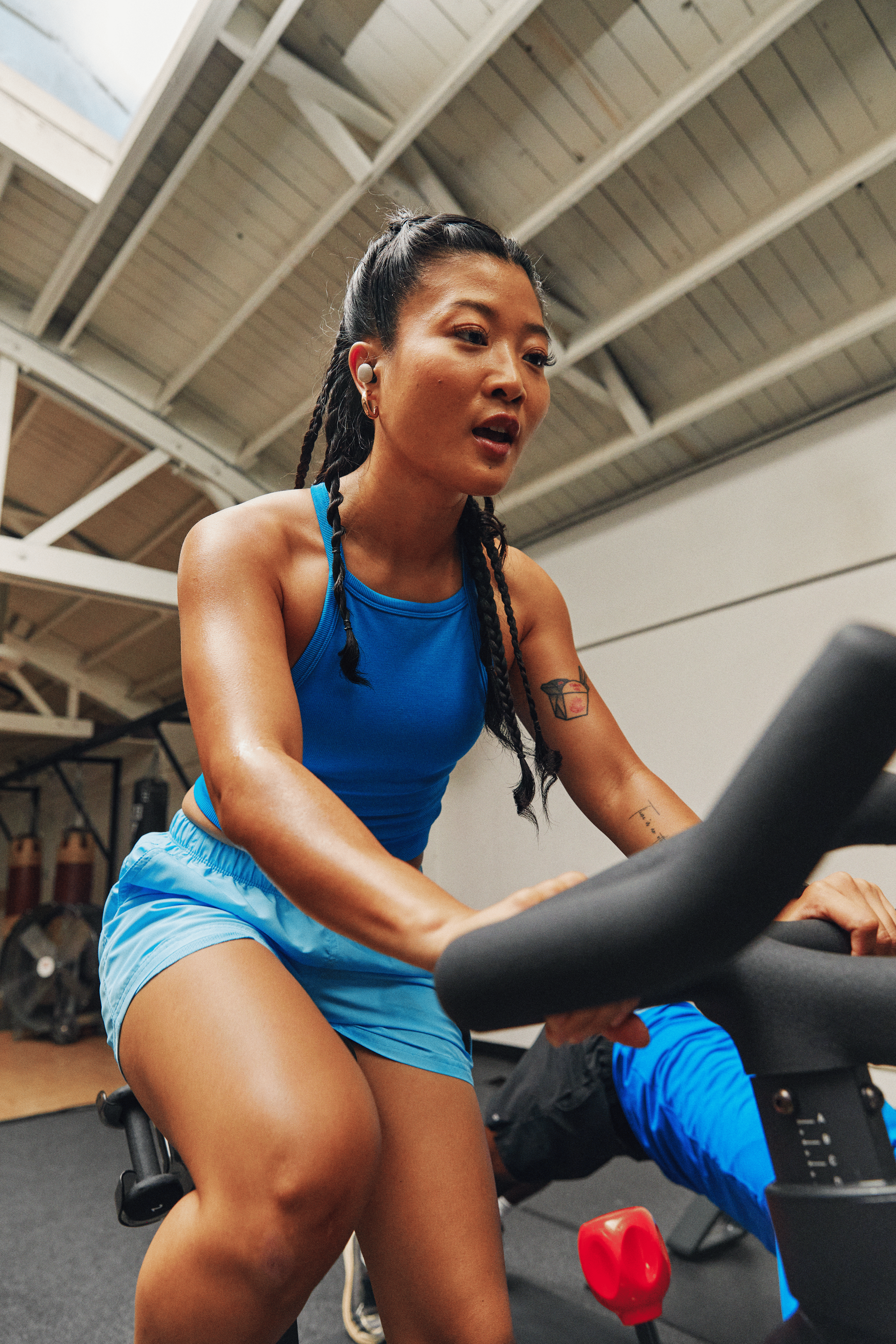 Young woman doing a HIIT workout on a Peloton Bike at the gym