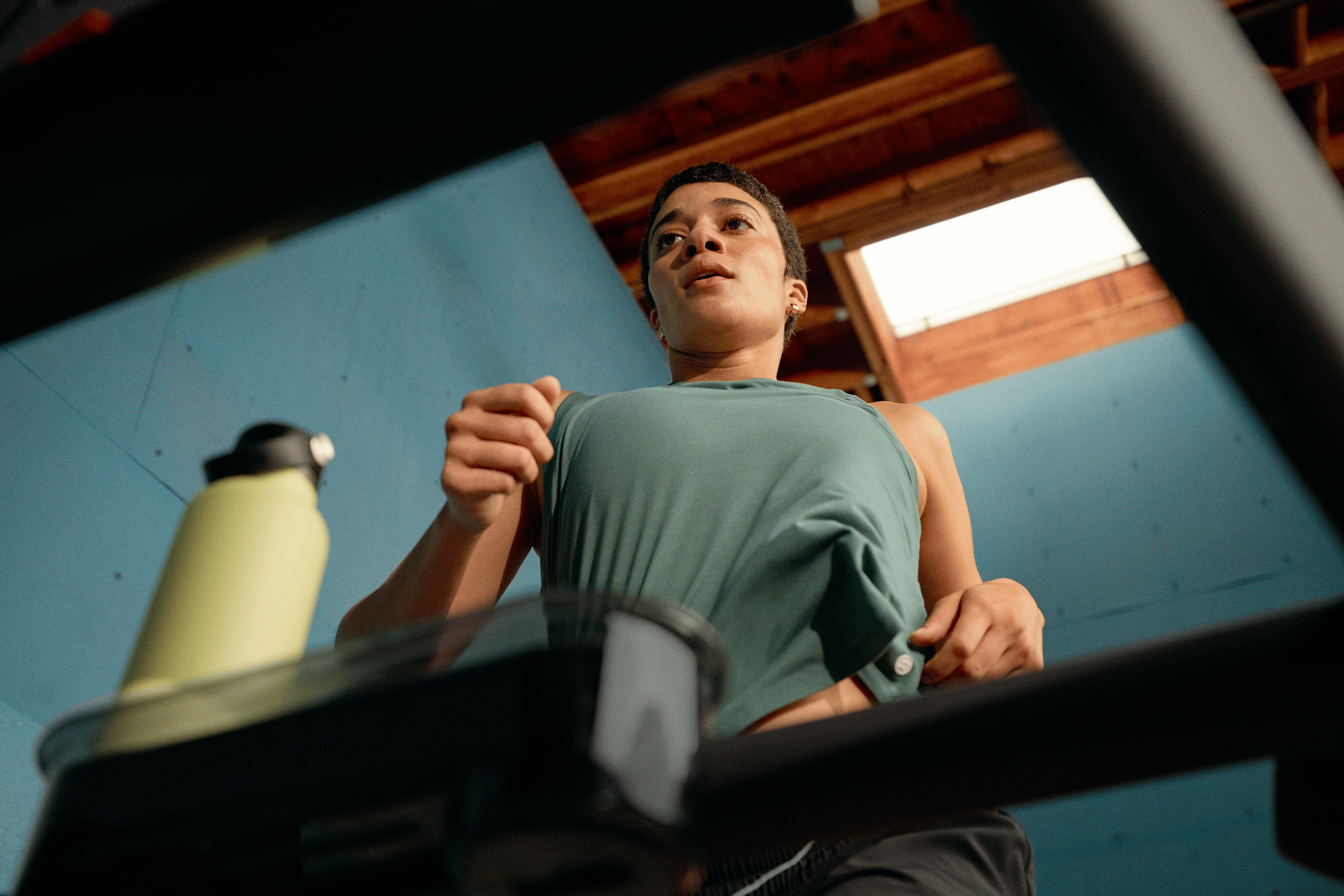Woman on a Peloton treadmill doing a sprint workout finisher after a running workout.
