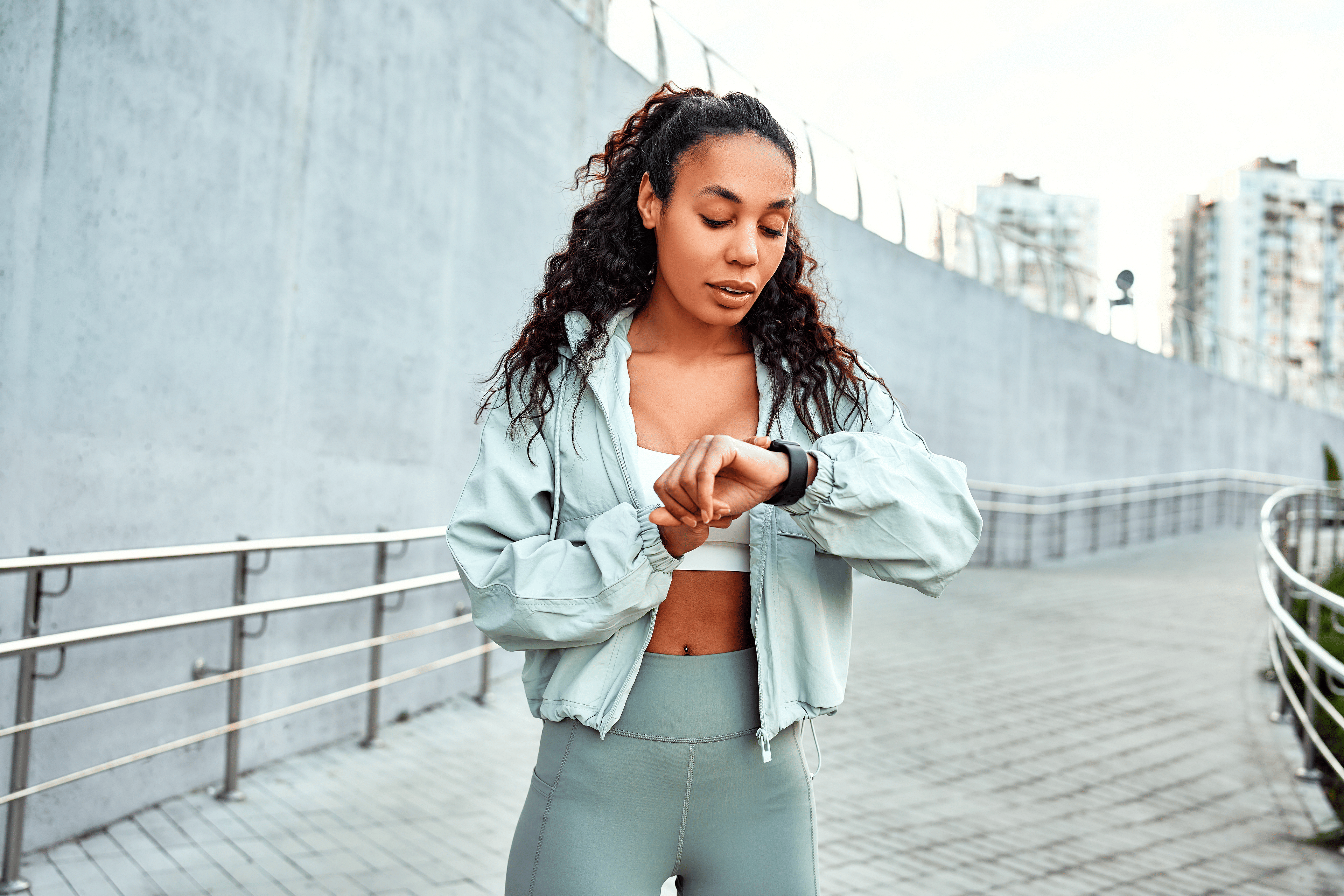 A woman in workout clothes checking her heart rate variability with the help of a smartwatch.