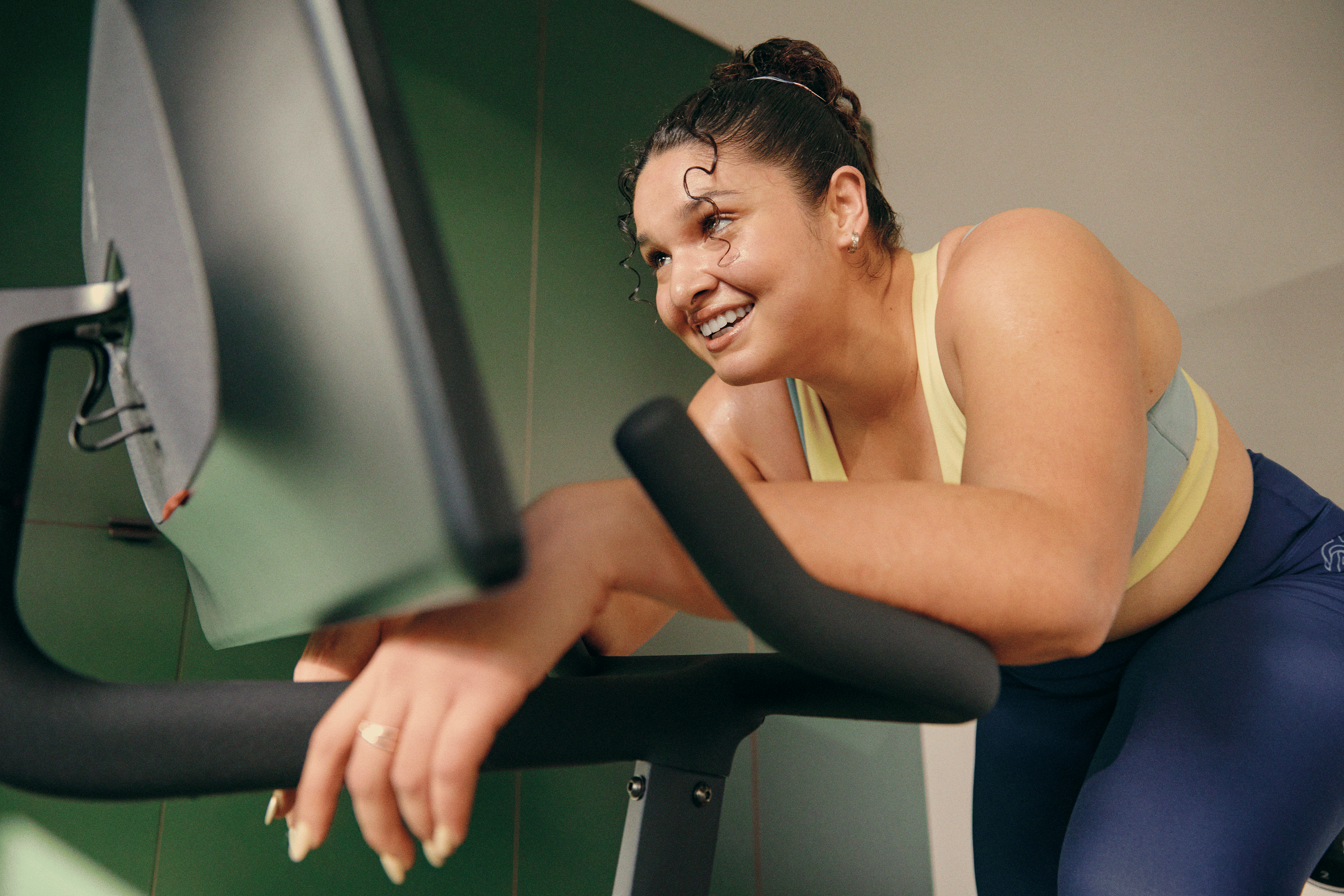 Woman on a Peloton Bike resting after doing a workout finisher.