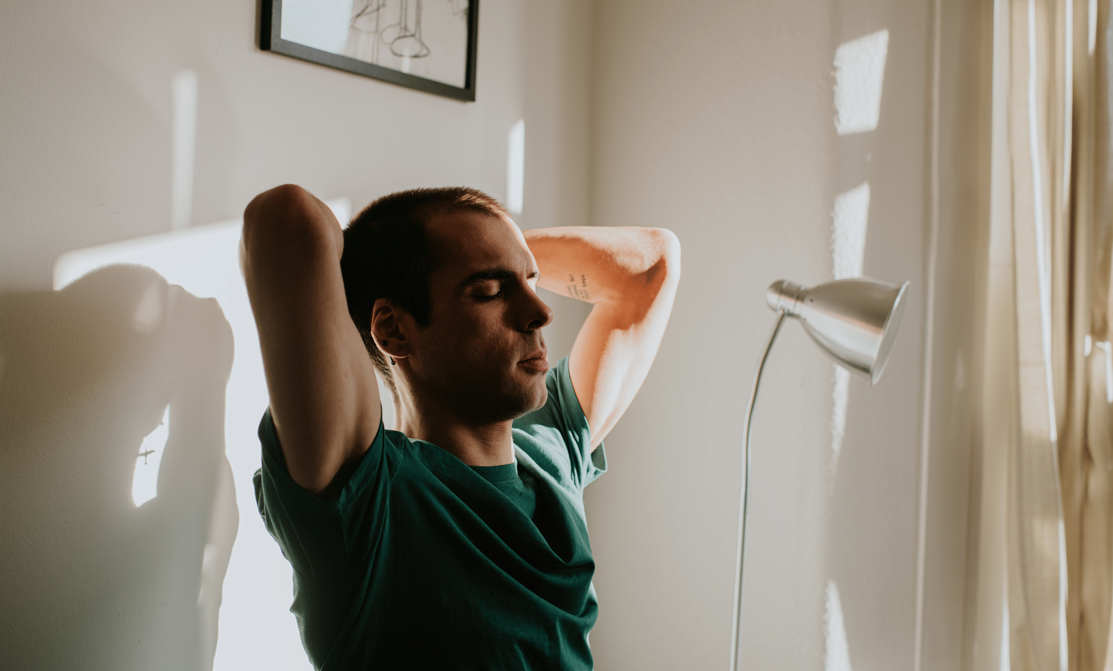 A man doing spinal mobility exercises while sitting at his desk at home.