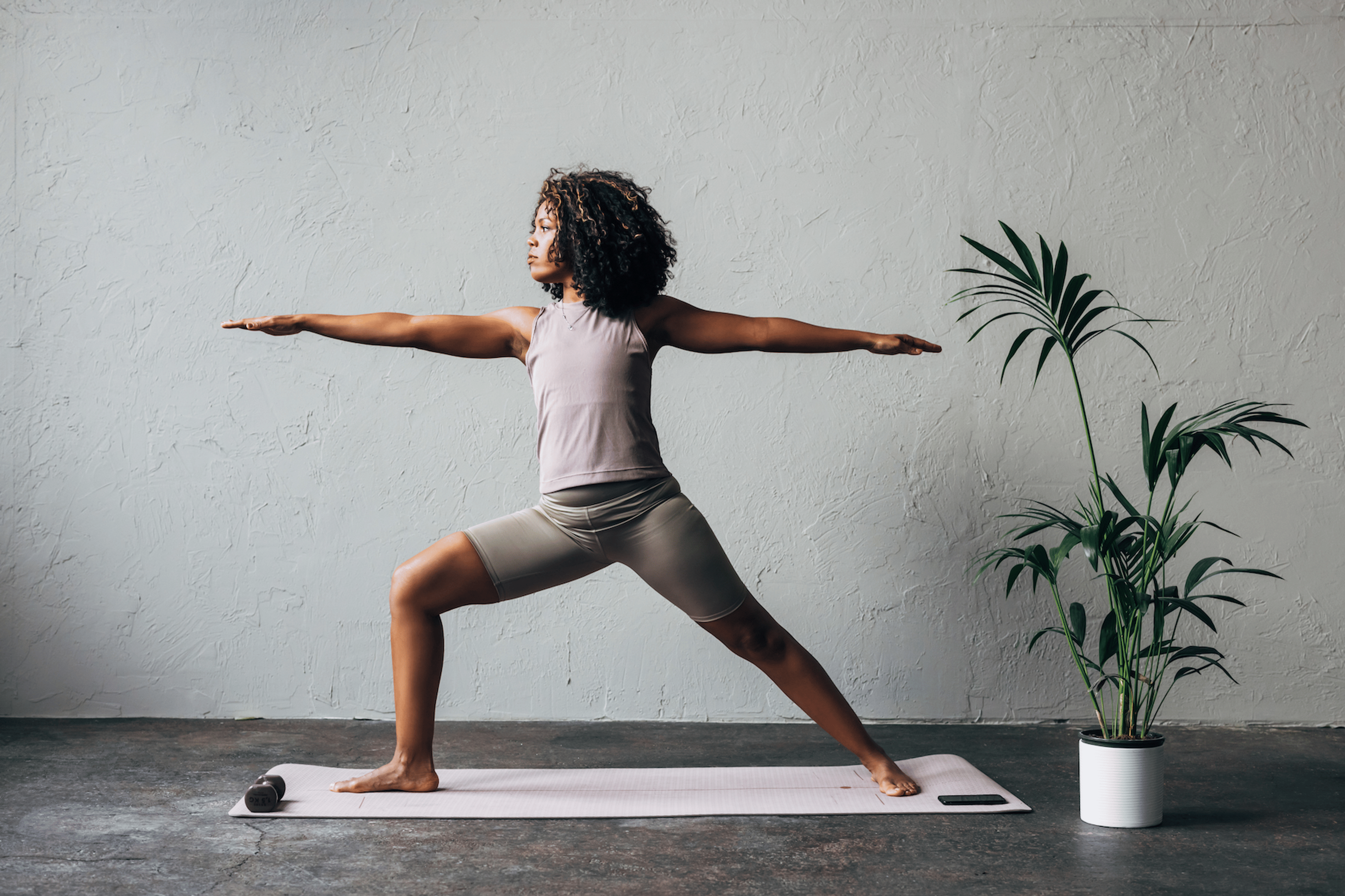 Woman practices Warrior 2 Pose during a yoga for athletes practice
