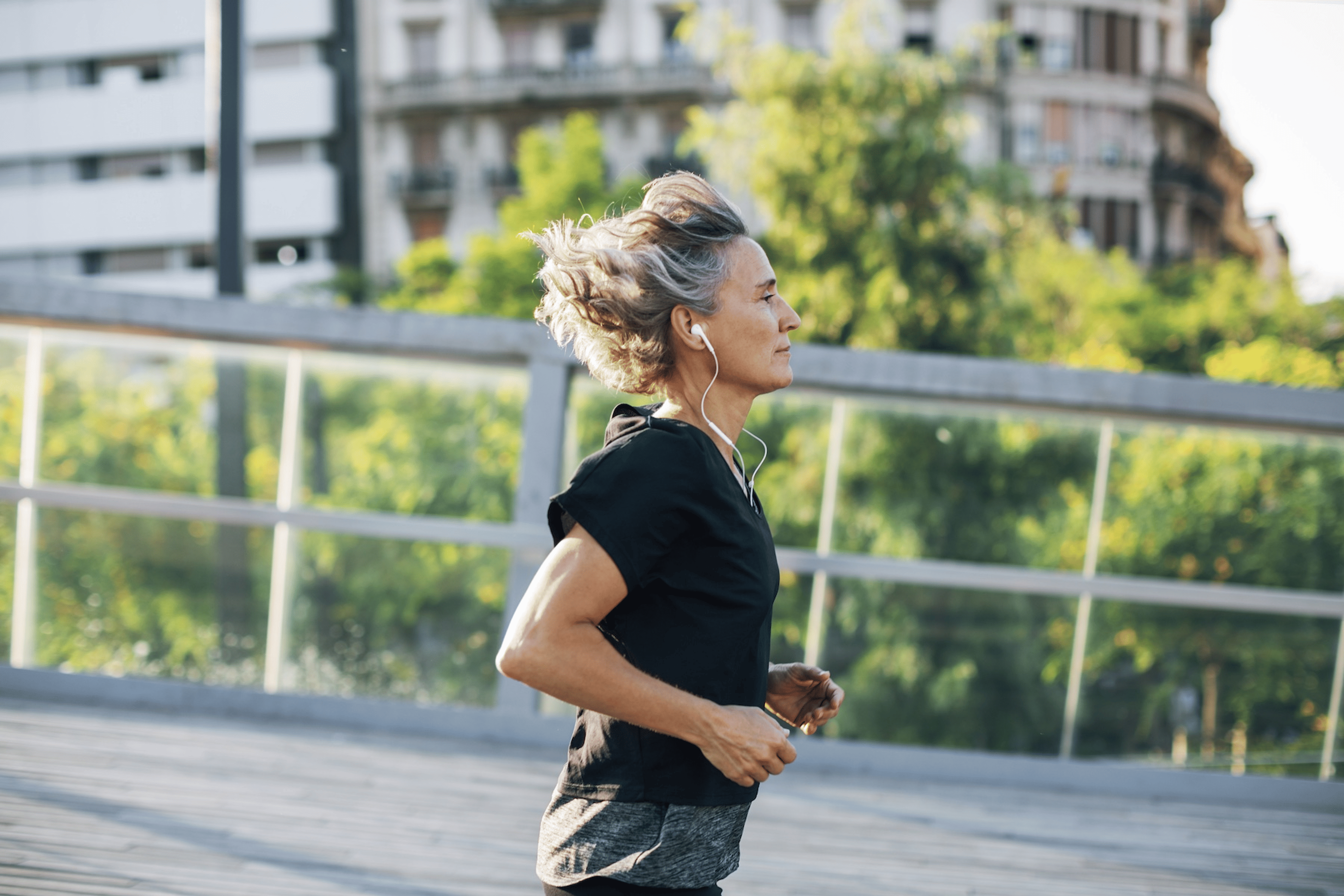 A mid-age woman running outside on a sunny day.