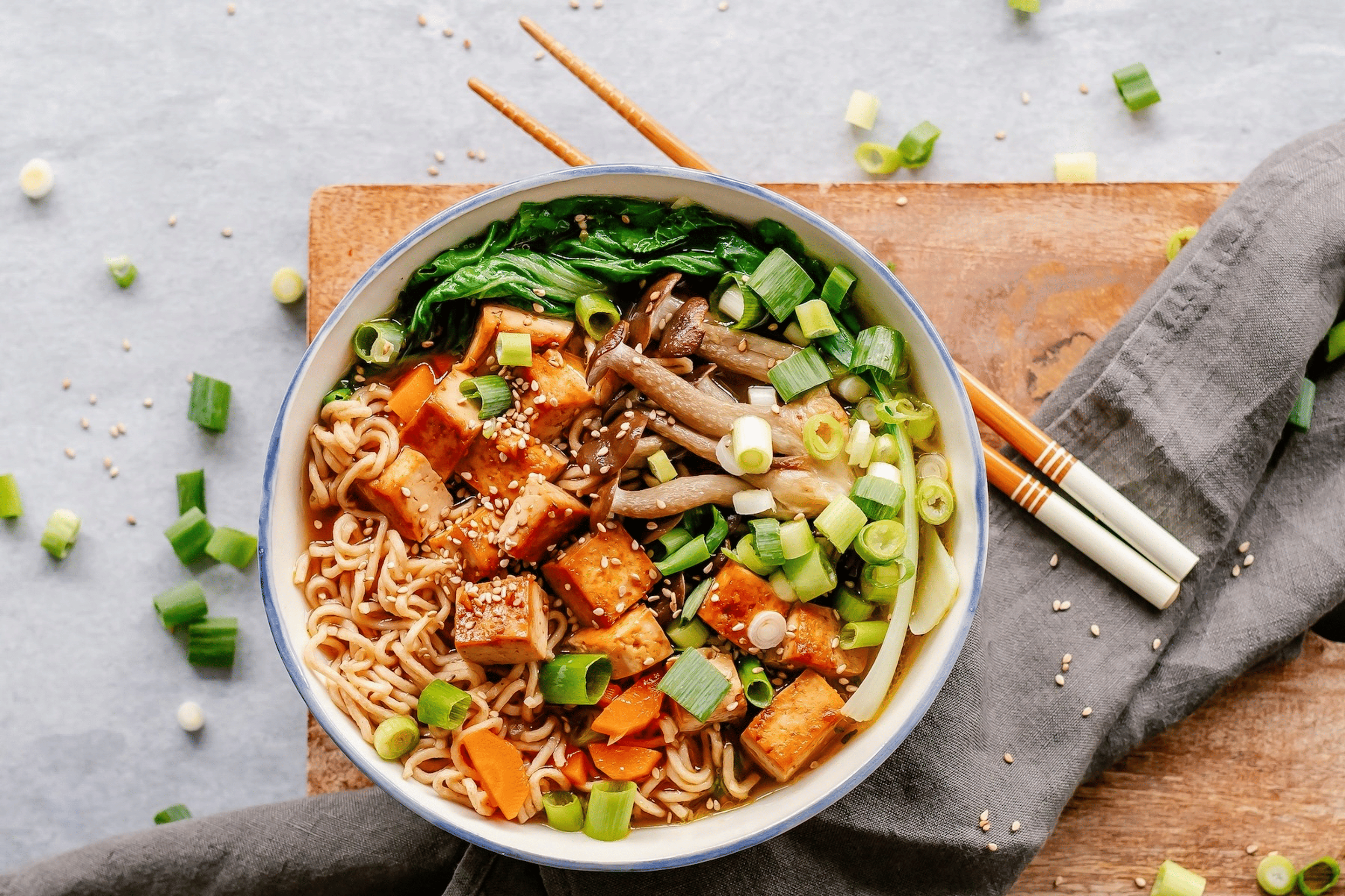 A bowl of miso soup with tofu (a non-meat protein source) and mushrooms and noodles.